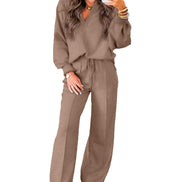 Woman wearing a brown tracksuit holding a phone on a white background
