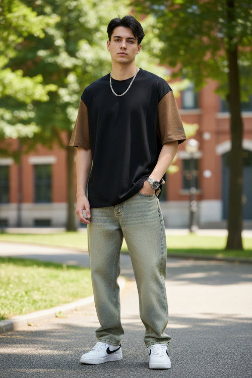 Person wearing a black and brown t-shirt with a plain background