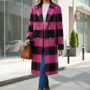 Woman wearing a pink and black checkered coat with a brown bag and boots on a white background