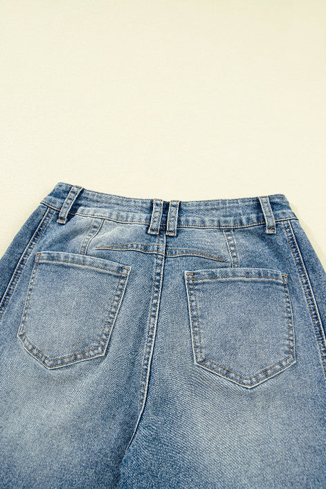 Close-up of a pair of blue jeans on a beige background