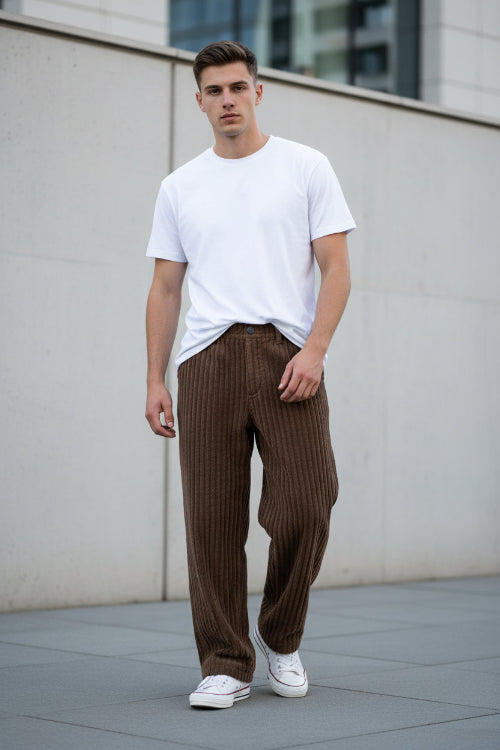 Brown corduroy pants worn by a person on a white background