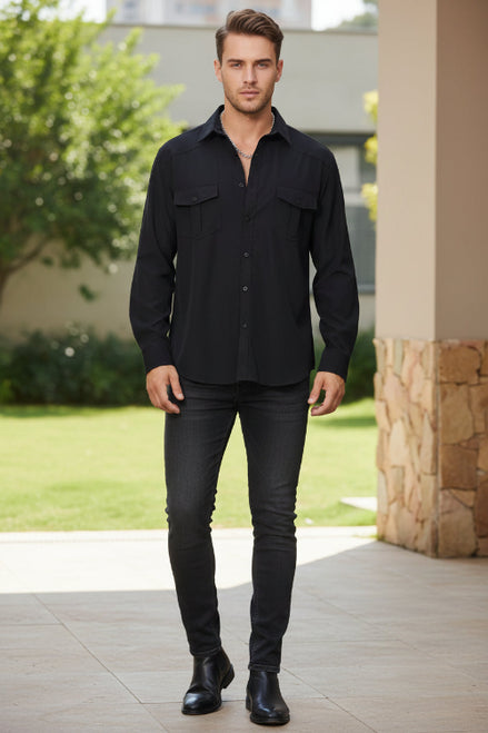 Man wearing a black shirt and pants standing outdoors.