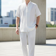 Person wearing a white outfit with a plain background