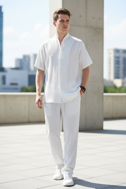 Person wearing a white outfit with a plain background