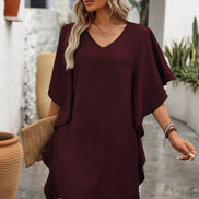 Woman wearing a burgundy dress with a neutral background