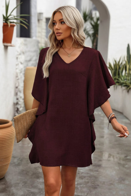Woman wearing a burgundy dress with a neutral background