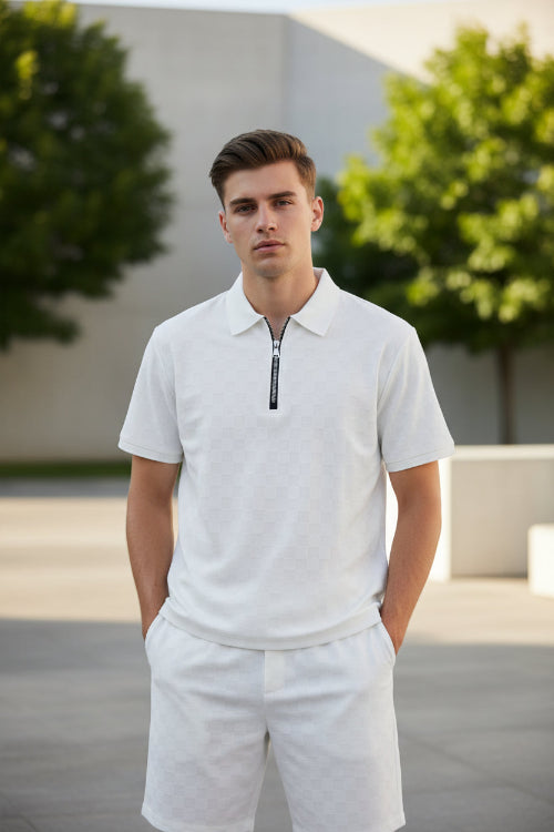 Man wearing a light gray polo shirt with a zipper and light gray pants on a white background