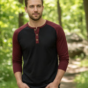 Black and burgundy long-sleeve henley shirt worn by a person against a neutral background