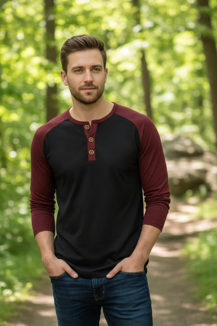 Black and burgundy long-sleeve henley shirt worn by a person against a neutral background