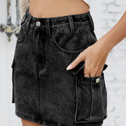 Person wearing a black denim skirt with a blurred background