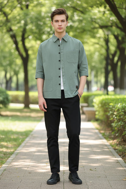 Person wearing a light green button-up shirt on a white background