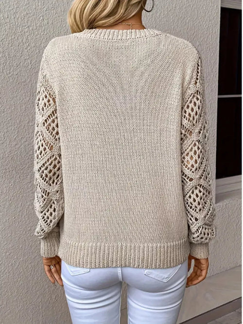 Beige sweater with lace sleeves worn by a person against a neutral background