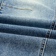 Close-up of blue denim fabric with stitching details