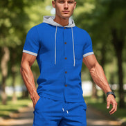 A man wearing a matching royal blue two-piece tracksuit with a short-sleeve button-front hoodie top 