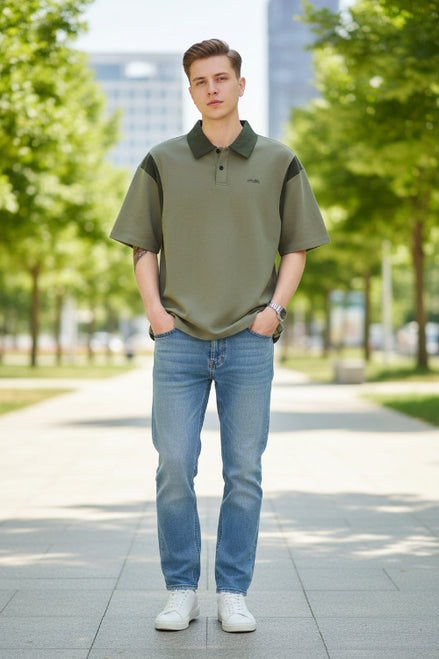 Person wearing a green polo shirt with a brand logo on a light gray background