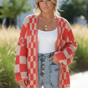 Person wearing a red and beige checkered cardigan over a white top and blue jeans on a white background