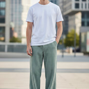 Green corduroy pants worn by a person on a white background