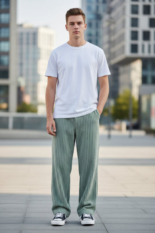 Green corduroy pants worn by a person on a white background