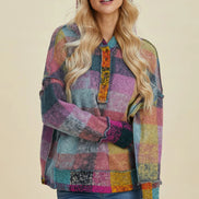 Woman wearing a colorful patchwork shirt against a beige background