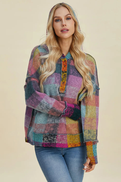 Woman wearing a colorful patchwork shirt against a beige background