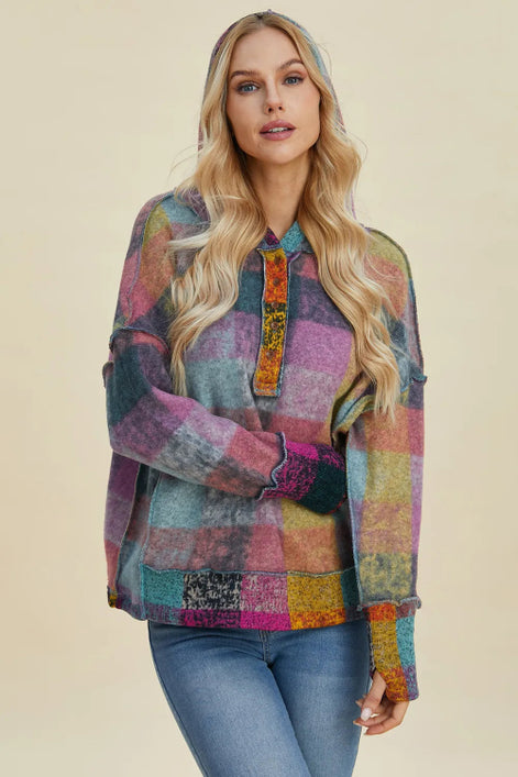 Woman wearing a colorful patchwork shirt against a beige background