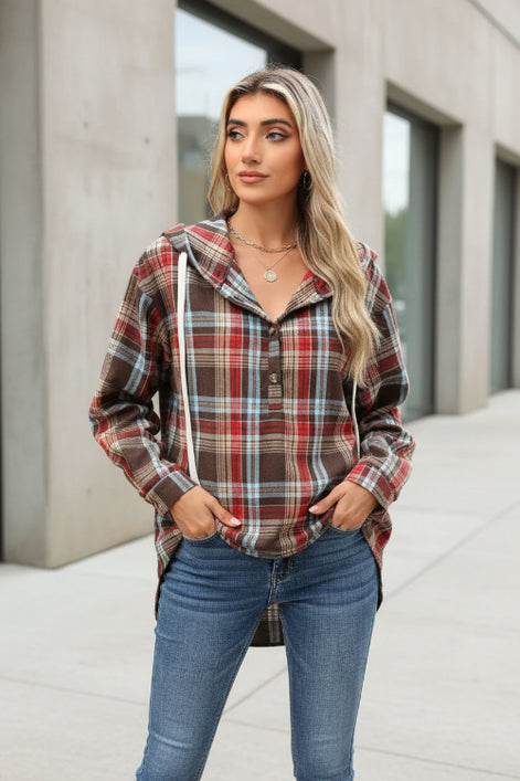 Woman wearing a plaid jacket standing outdoors.