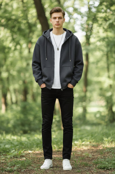Person wearing a dark gray hoodie on a light gray background