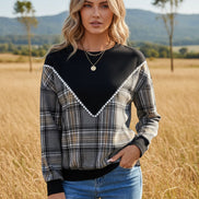 Person wearing a black and plaid long-sleeve top with a white background