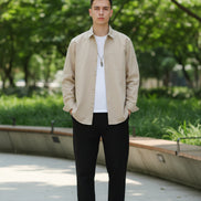 Beige shirt worn by a person on a gray background