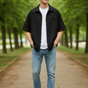 Black short-sleeve shirt over a white shirt on a white background