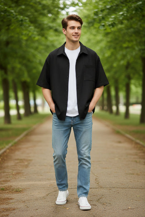 Black short-sleeve shirt over a white shirt on a white background