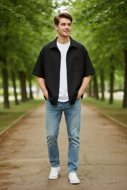 Black short-sleeve shirt over a white shirt on a white background