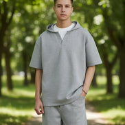 Person wearing a gray outfit with a plain background