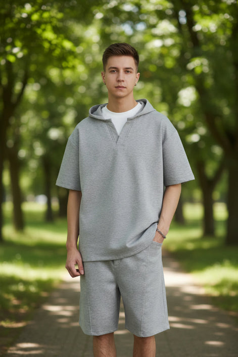Person wearing a gray outfit with a plain background