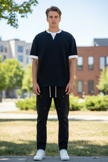 Person wearing a black and white polo shirt on a white background