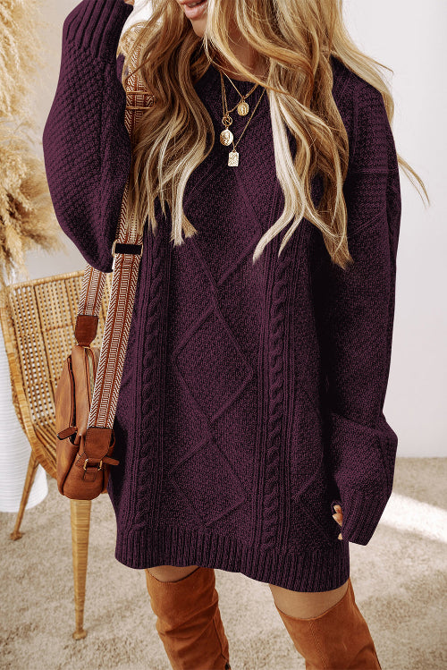 A woman wearing a chunky cable-knit sweater in deep plum purple, styled with a brown crossbody bag 
