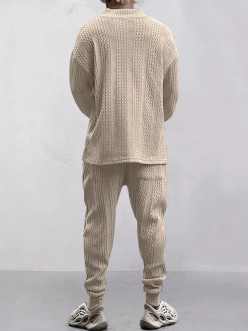 A person shown from the back wearing a matching beige cable-knit sweater and jogger pants set, 