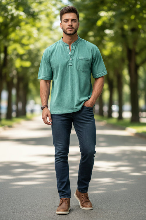 Man wearing a green short-sleeve henley shirt with a pocket on a white background