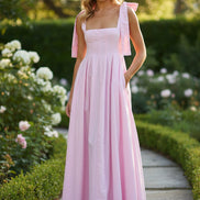 Pink dress with bow straps on a white background