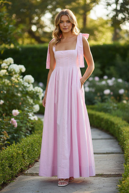 Pink dress with bow straps on a white background