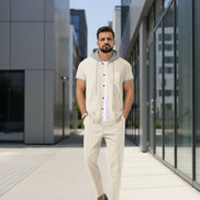A man wearing a light beige short-sleeve button-up shirt with a gray hood and gray trim, 