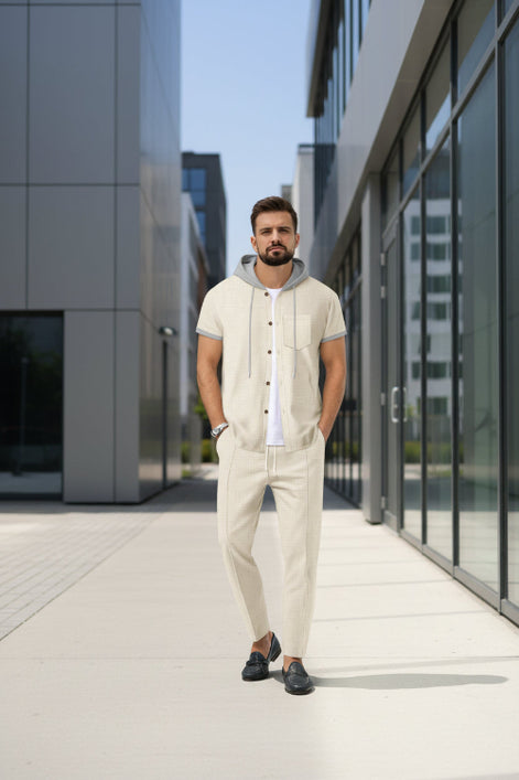 A man wearing a light beige short-sleeve button-up shirt with a gray hood and gray trim, 