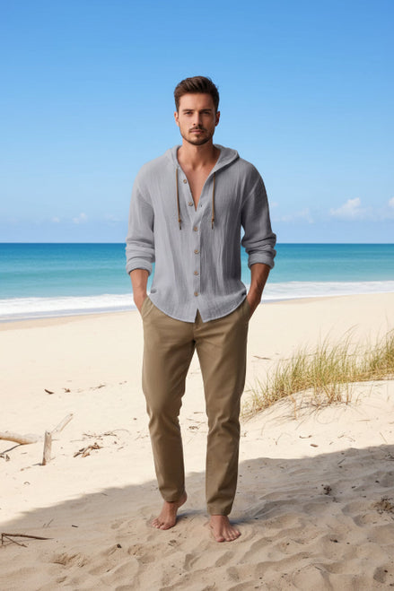 Man wearing a light gray hoodie with a beach in the background