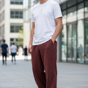Maroon corduroy pants worn by a person on a white background