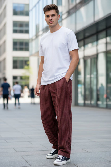 Maroon corduroy pants worn by a person on a white background