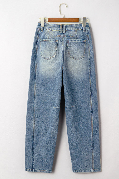 Pair of blue jeans on a hanger against a white background