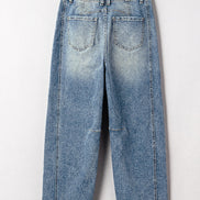 Pair of blue jeans on a hanger against a white background