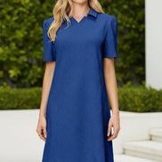 Woman wearing a blue dress against a beige background