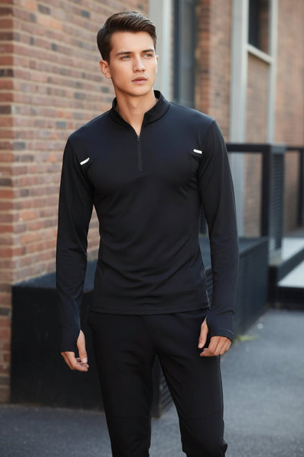 Person wearing a black athletic outfit sitting on a metal bench with a cityscape background.
