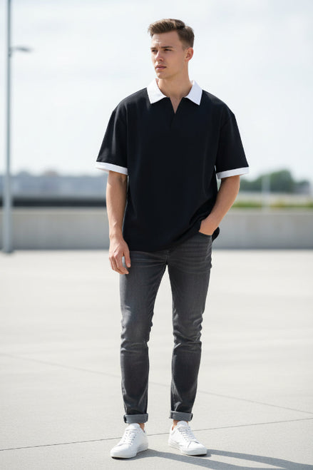 Person wearing a black t-shirt with white trim on a white background